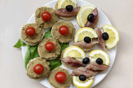 Various canape with vegetables and herring on plateの写真素材