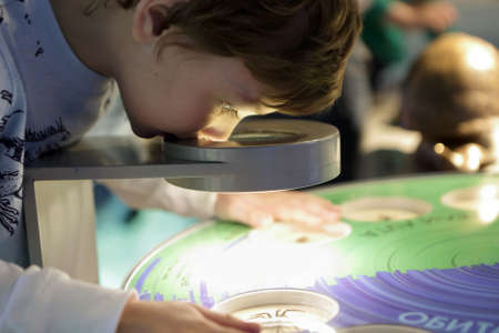 Kid scans a beetle in a microscopeの写真素材