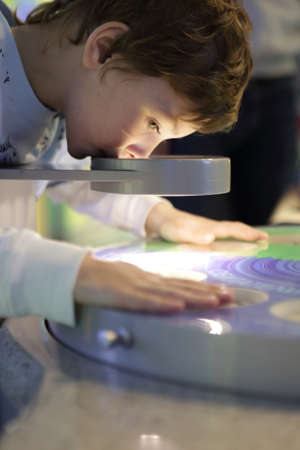 Preschooler scans a beetle in a microscopeの写真素材