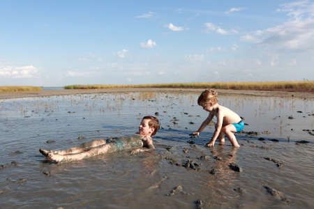 Portrait of two children in healing mudの写真素材