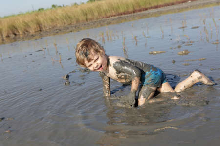Child is crawling in healing mud, Russiaの写真素材