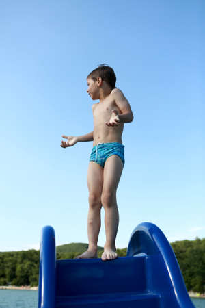 Child standing on a waterslide of catamaranの写真素材