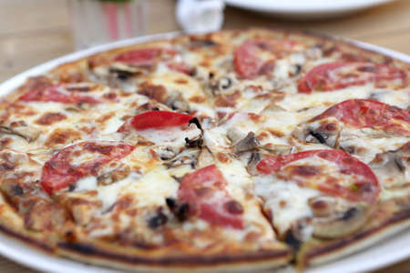 Pizza with mushrooms on a table in cafeの写真素材