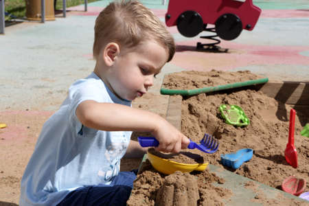 Child playing with toys in the sandboxの写真素材
