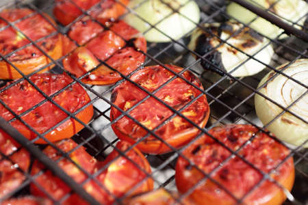 Cooking of tomatoes on the grill at picnicの写真素材