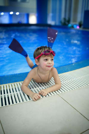 Portrait of kid in flippers on the edge of the poolの写真素材
