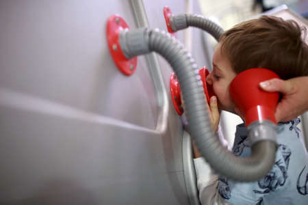 Child is studying acoustics in a museumの写真素材