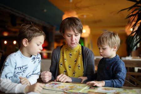 Family choosing dishes at table in the restaurantの写真素材