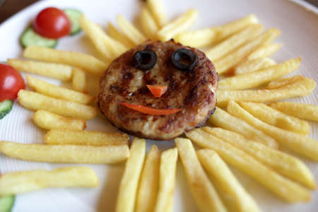 Plate with cutlet and french fries in a cafeの写真素材
