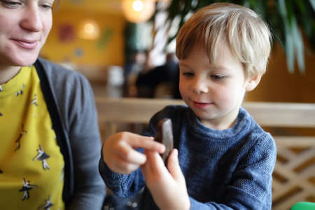 Child has cake biscuits in a cafeの写真素材