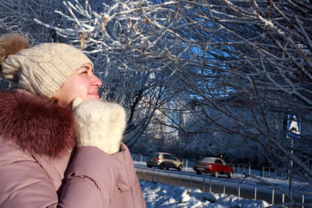 Frozen woman posing on tree background in winter park