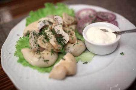 Salted pickled mushrooms on a white plateの写真素材