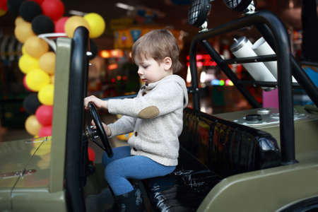 Child driving toy car at amusement park