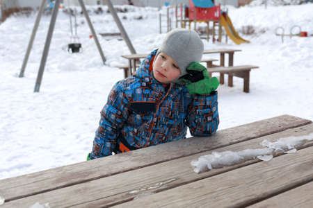 Child at wooden table in winter playgroundの写真素材