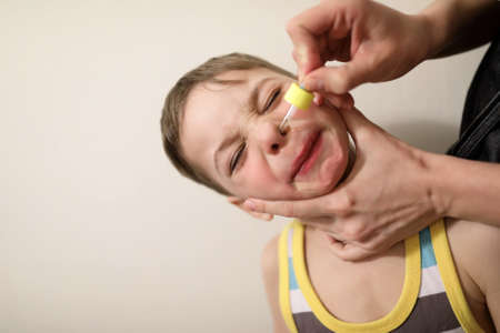 Person treats the child runny nose at homeの写真素材