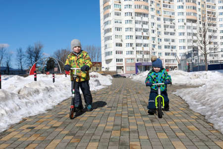 Two brothers riding at playground in springの写真素材