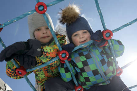 Portrait of brothers on climbing net in springの写真素材