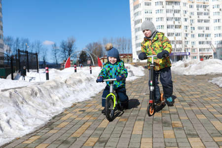 Two boys riding at playground in springの写真素材