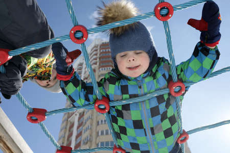 Portrait of boys on climbing net in springの写真素材
