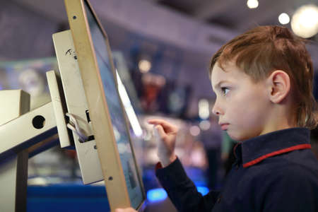 Boy using touch screen in a libraryの写真素材