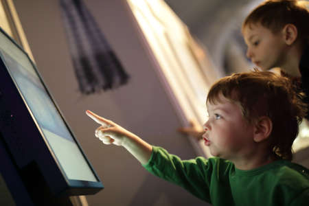 Boy looking at monitor in a libraryの写真素材