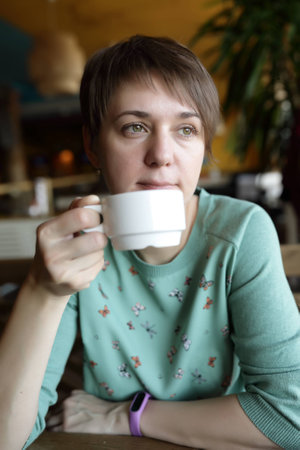 Woman has tea at table in a restaurant
