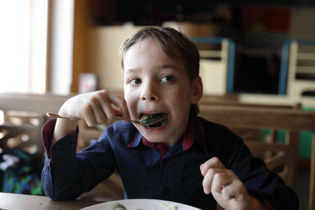 Boy has mashed potatoes in a cafe
