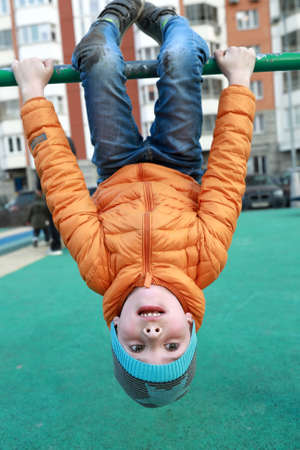 Boy on horizontal bar at outdoor playground