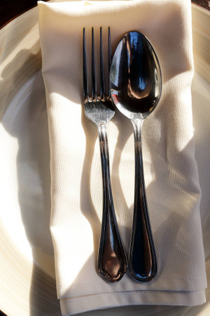 Spoon with fork on serviette in restaurantの写真素材