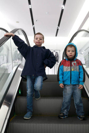 Portrait of two brother on moving escalatorの写真素材