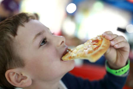 Child has pizza in an italian cafeの写真素材