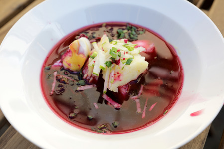 Cold beetroot soup in plate on table