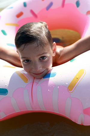 Child on an inflatable ring in the seaの写真素材
