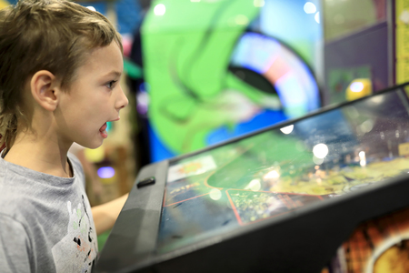 Boy playing arcade game in redemption center