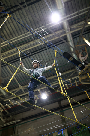 Kid climbing in the adventure park indoor