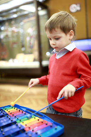 Serious boy playing xylophone in music classの写真素材