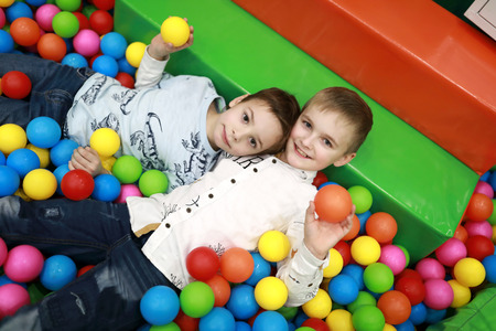 Brothers playing in ball pool at playground