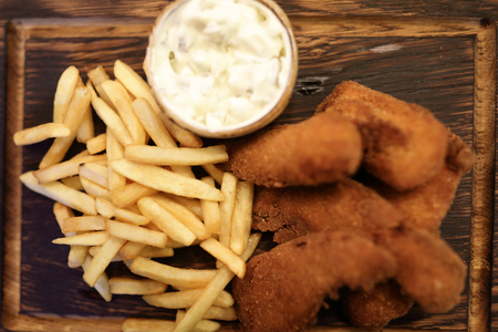 Fish and chips on wooden plate in restaurantの写真素材