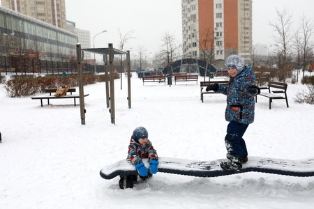 Child keeps balance at outdoor playground in winterの写真素材