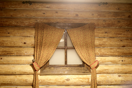 Window with curtains in a log cabinの写真素材