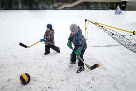 Children play bandy on a winter playgroundの写真素材