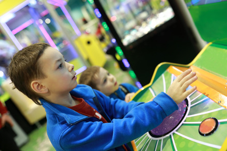 Two brothers playing arcade game in amusement park