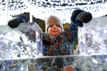 Boy posing behind ice wall at nightの写真素材