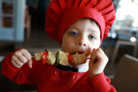 Portrait of boy has Shashlik in a restaurantの写真素材