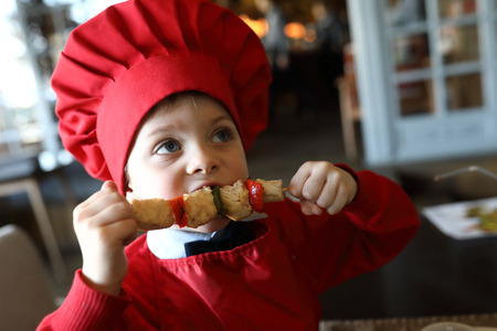 Portrait of kid has Shashlik in a restaurantの写真素材