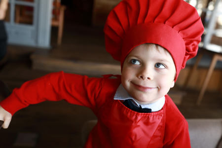 Portrait of kid in red cap cookの写真素材