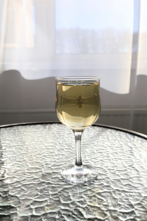 Glass of white wine on table in cafeの写真素材