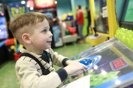 Boy plays arcade game in indoor amusement parkの写真素材