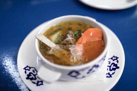 Bowl with shurpa on blue table in restaurantの写真素材