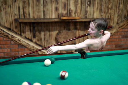 Portrait of smiling boy playing American billiards